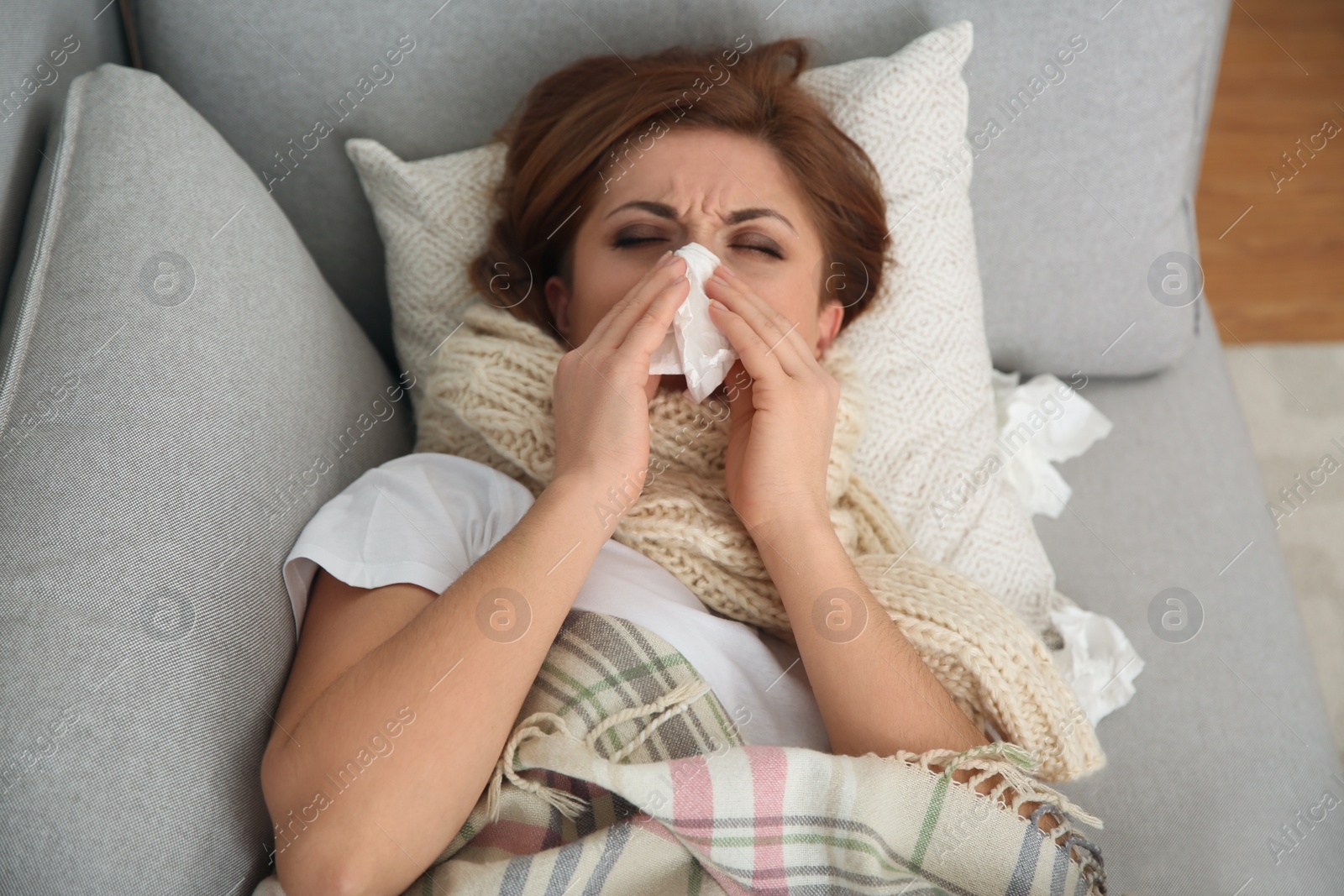 Photo of Sick woman lying on sofa at home. Influenza virus