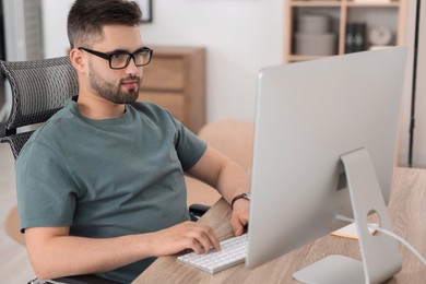 Photo of Programmer working with computer at desk in office