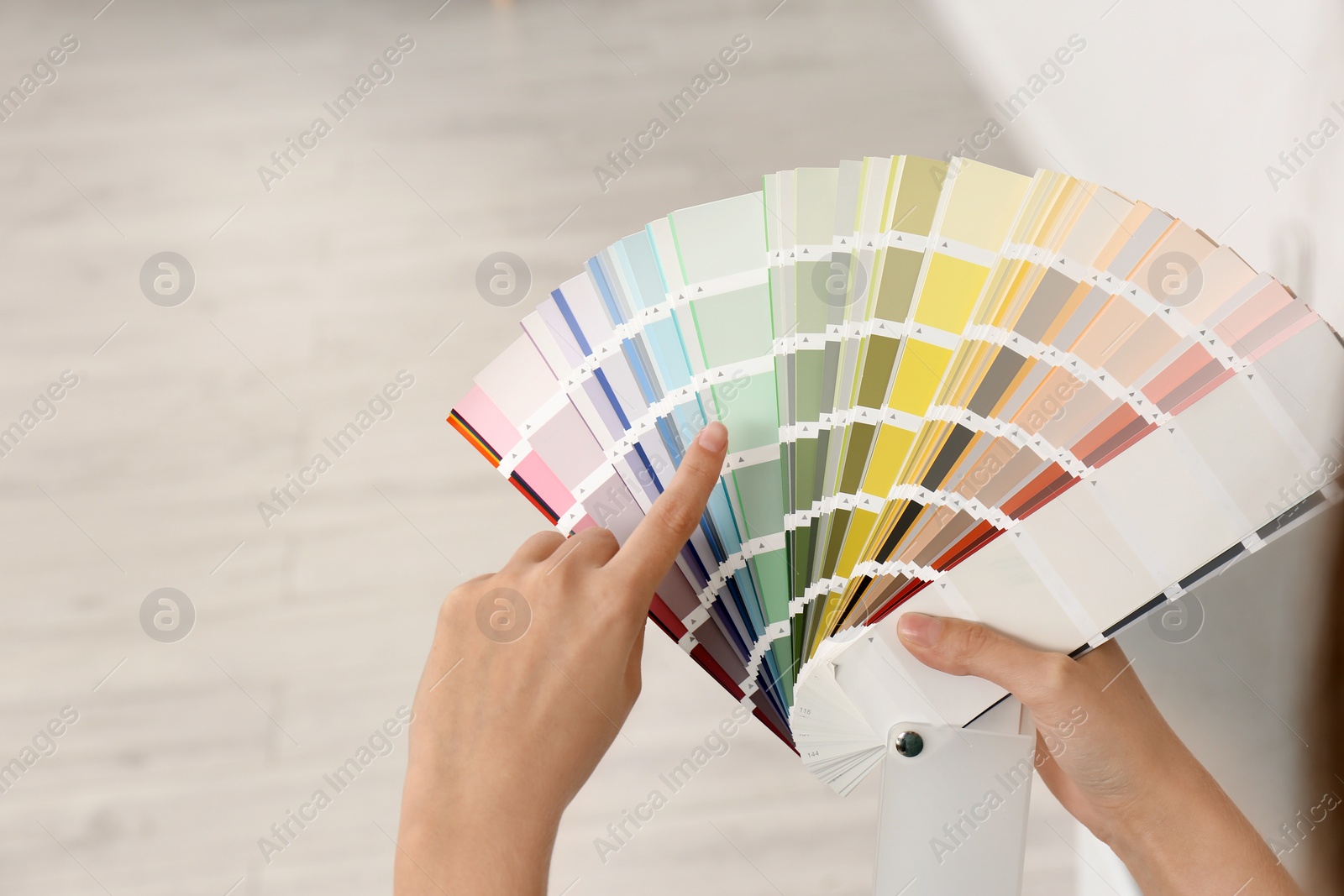 Photo of Female interior designer with color palette samples indoors, closeup. Space for text