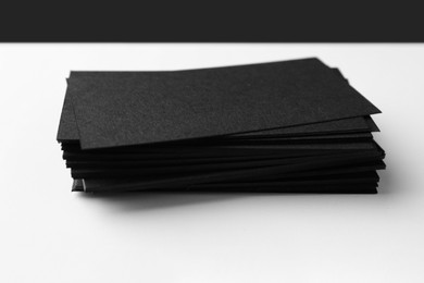 Photo of Blank black business cards on white background, closeup