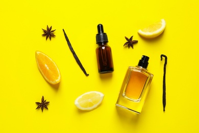 Photo of Flat lay composition with elegant perfume on yellow background