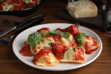 Photo of Tasty ravioli with tomato sauce served on wooden table