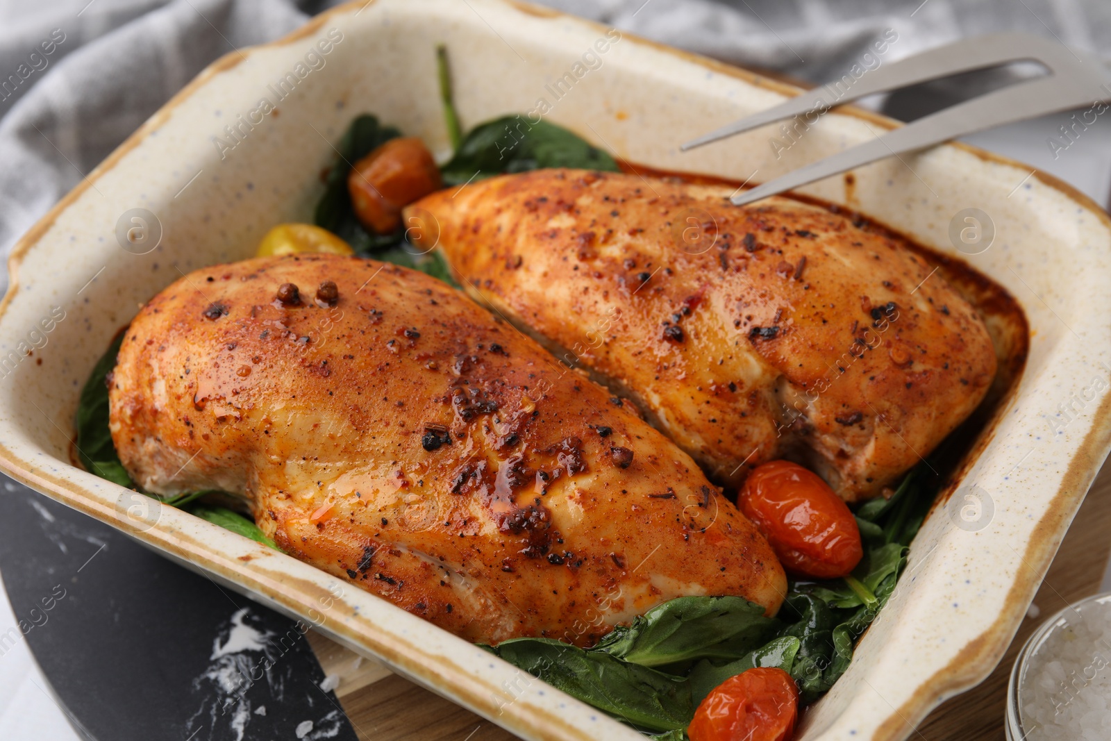 Photo of Baked marinated chicken fillets on white table, closeup