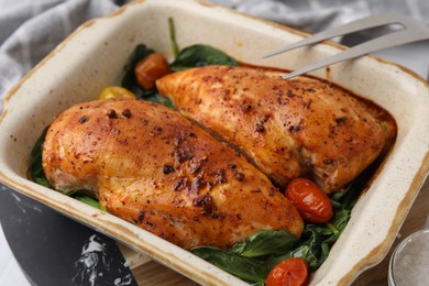Photo of Baked marinated chicken fillets on white table, closeup