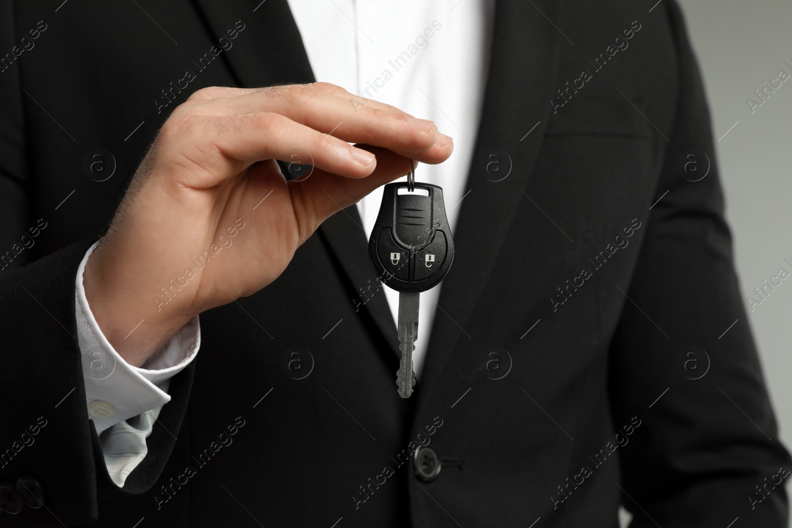 Photo of Young man holding new car key, closeup