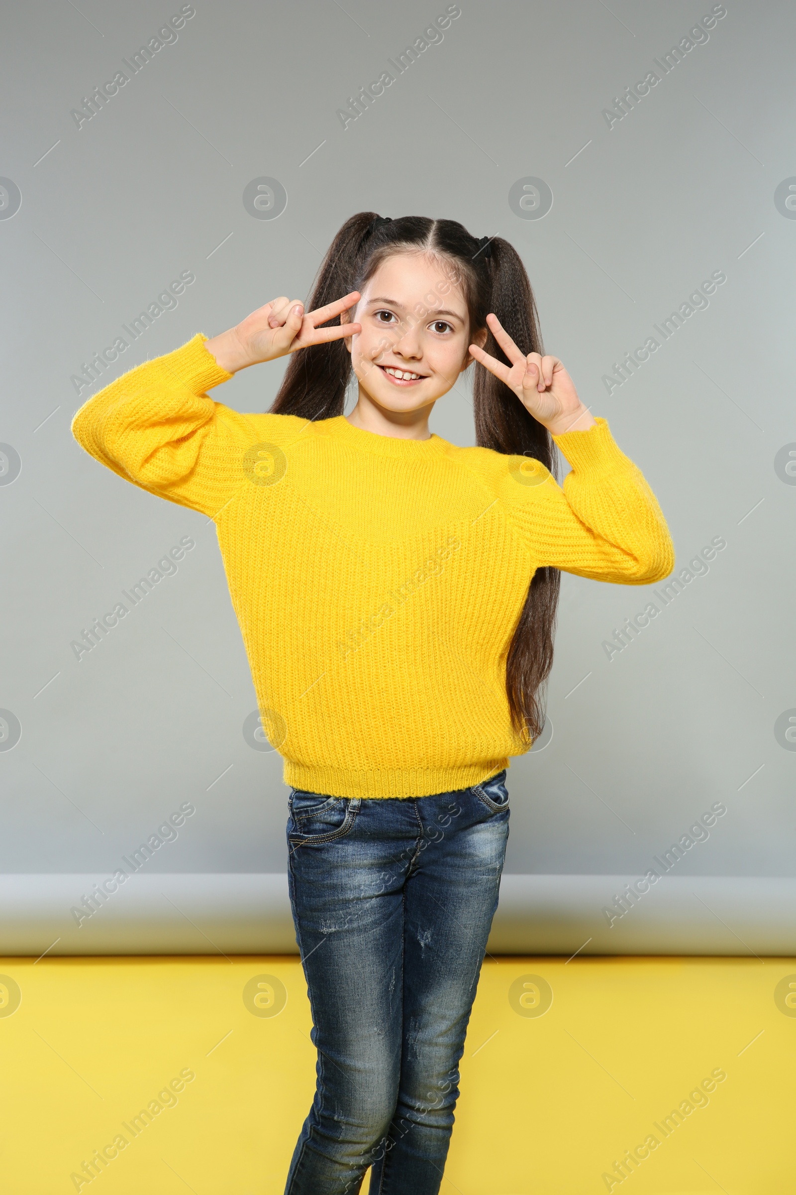 Photo of Portrait of little girl posing on grey background