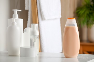 Photo of Bottle of shampoo and toiletries on white table in bathroom