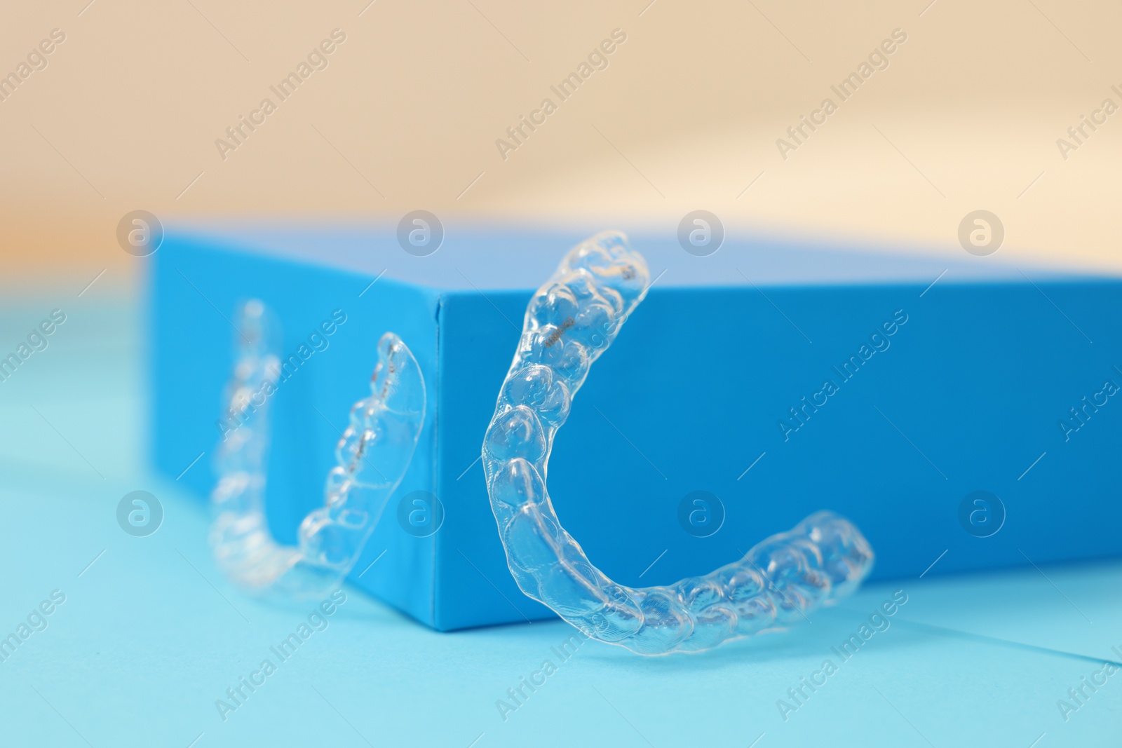 Photo of Transparent dental aligners on color background, closeup