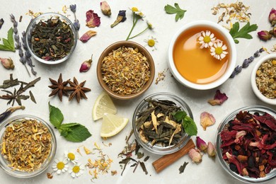 Flat lay composition with fresh brewed tea and dry leaves on light table