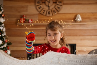 Photo of Cute little girl performing puppet show at home