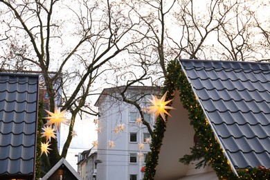 Christmas fair stalls decorated with beautiful festive lights and pine garland outdoors