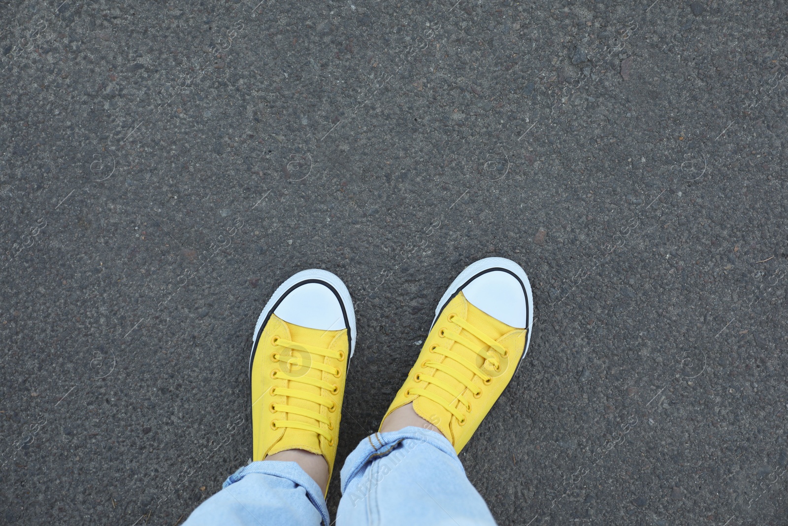 Photo of Woman standing on asphalt, top view. Space for text