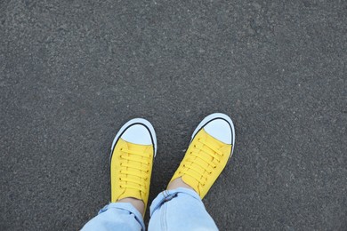 Photo of Woman standing on asphalt, top view. Space for text