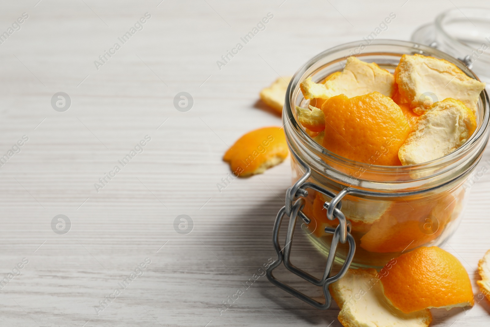 Photo of Orange peels preparing for drying on white wooden table, closeup. Space for text