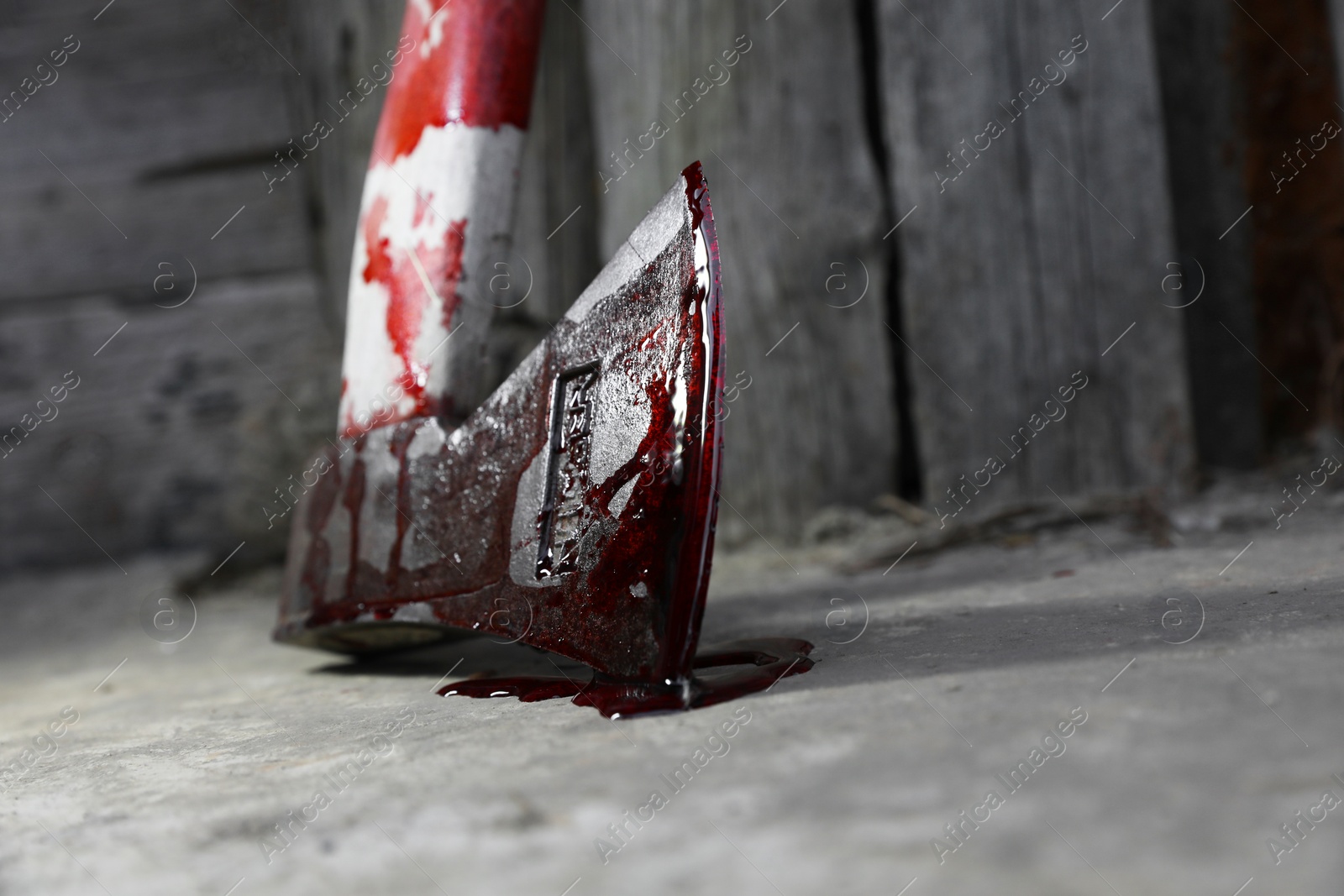 Photo of Axe with blood on floor indoors, closeup. Space for text
