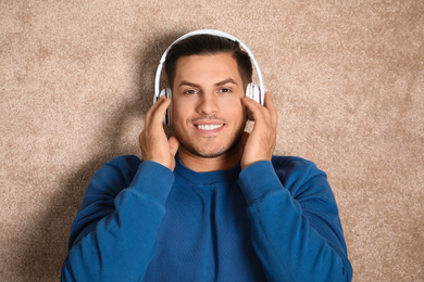 Man listening to audiobook on floor, top view