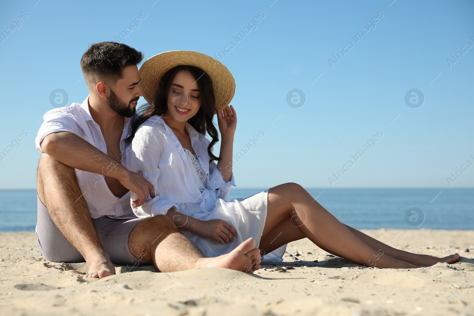 Photo of Happy young couple on beach near sea. Honeymoon trip