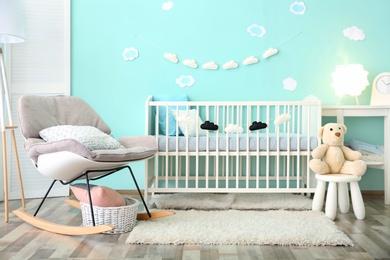 Photo of Modern baby room interior with crib and rocking chair