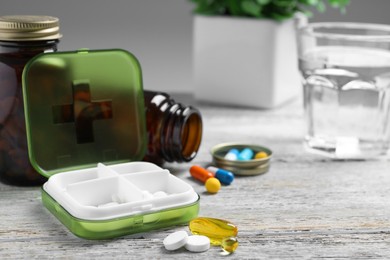 Pill box with medicaments on wooden table. Space for text