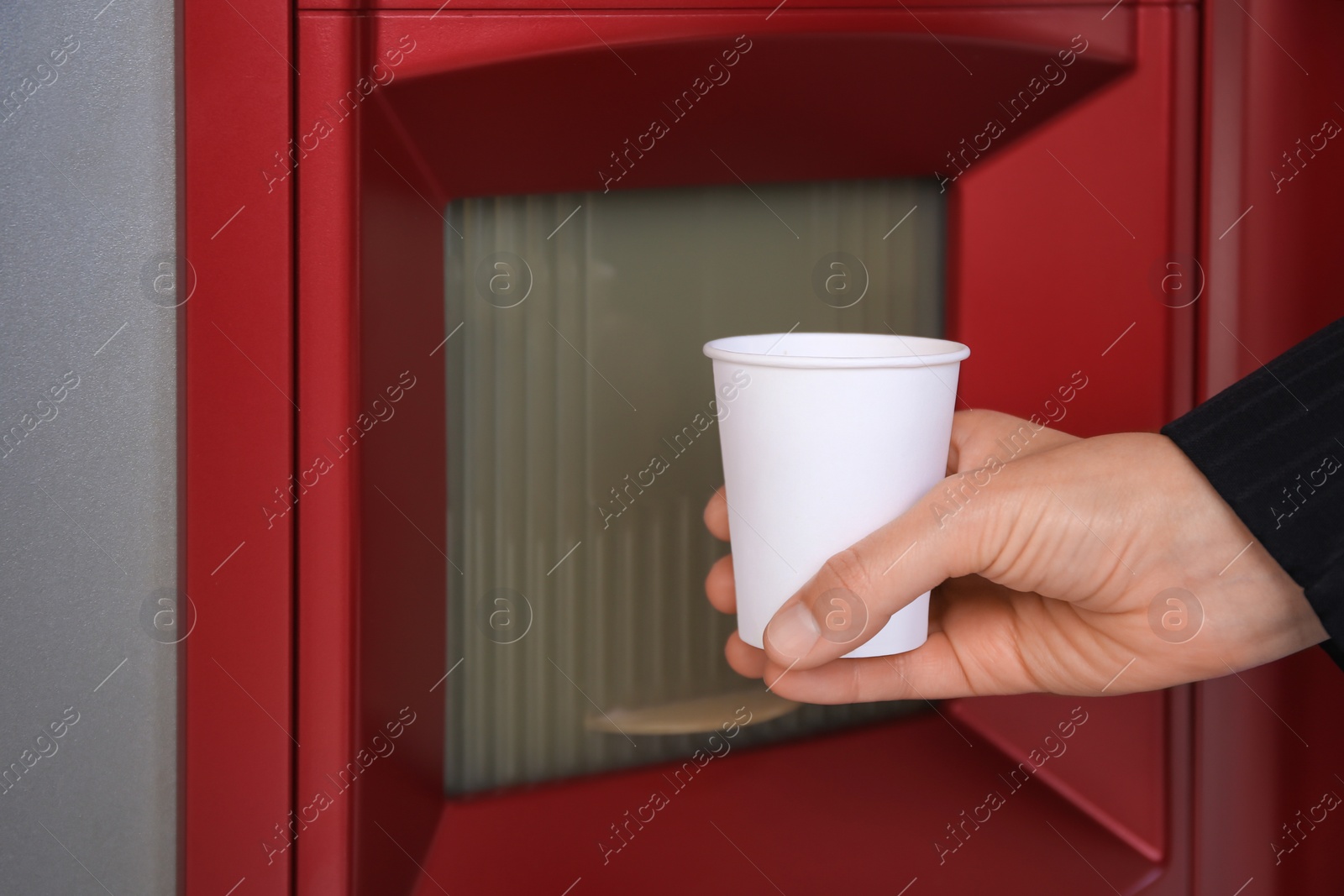 Photo of Woman taking paper cup with coffee from vending machine, closeup