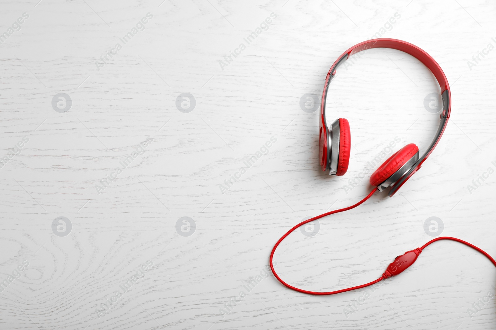 Photo of Stylish modern headphones and space for text on wooden background, top view