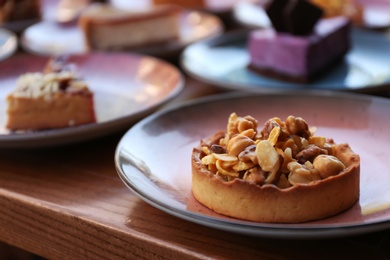 Photo of Plate with delicious cake on wooden table