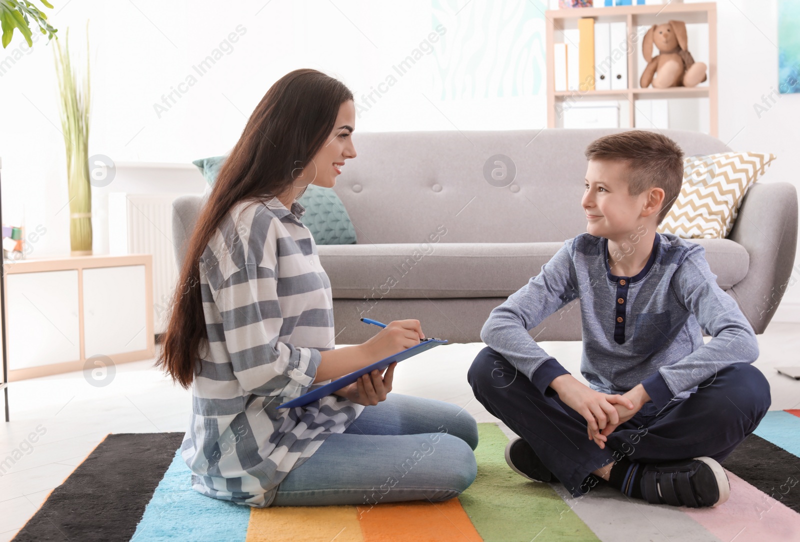 Photo of Child psychologist working with boy in office