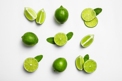 Photo of Flat lay composition with fresh juicy limes and mint on white background