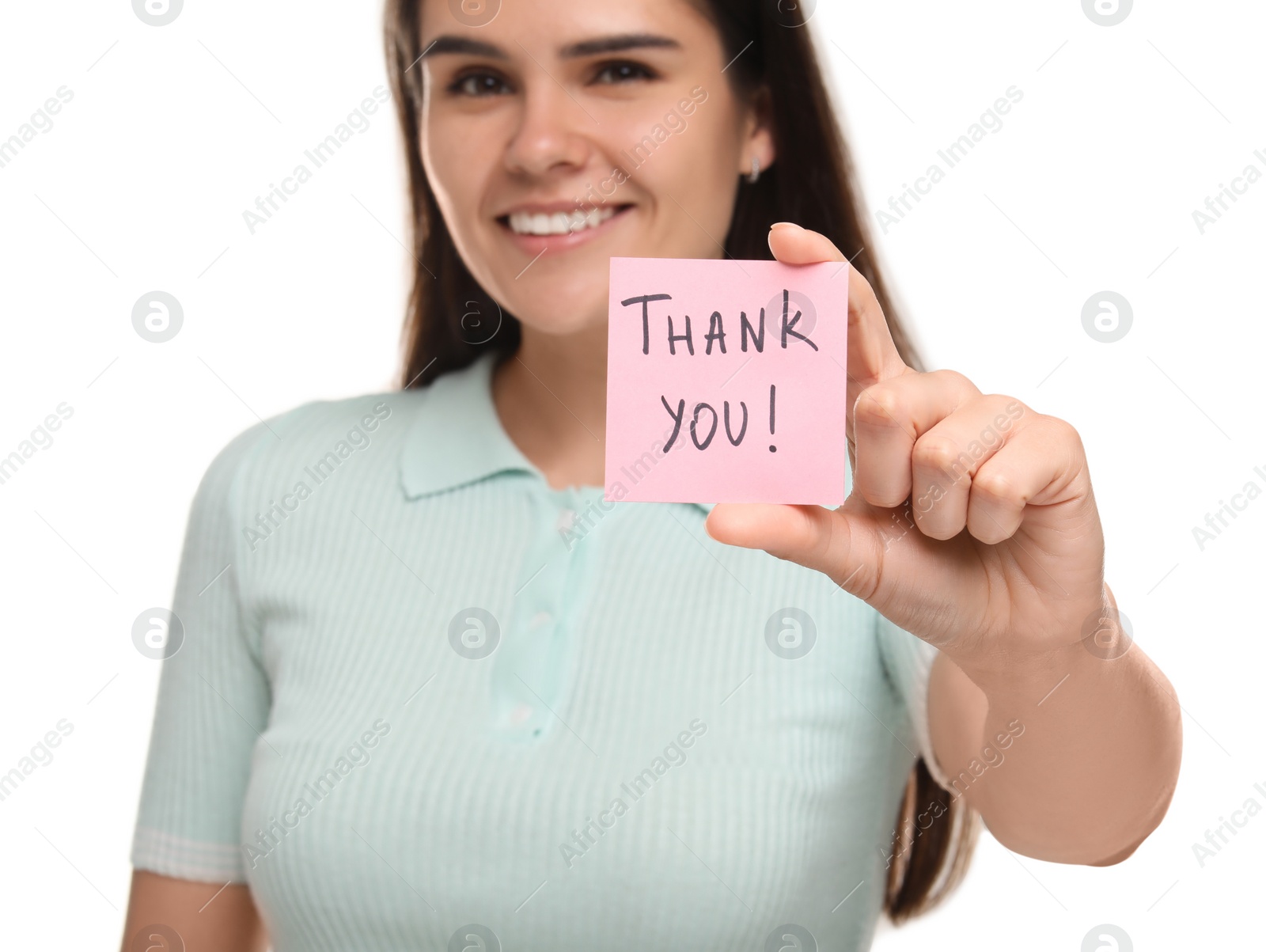 Photo of Happy woman holding paper note with phrase Thank You on white background, selective focus