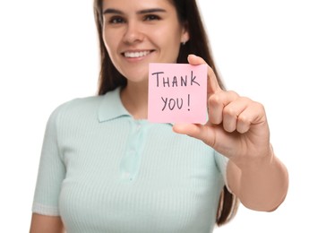 Happy woman holding paper note with phrase Thank You on white background, selective focus
