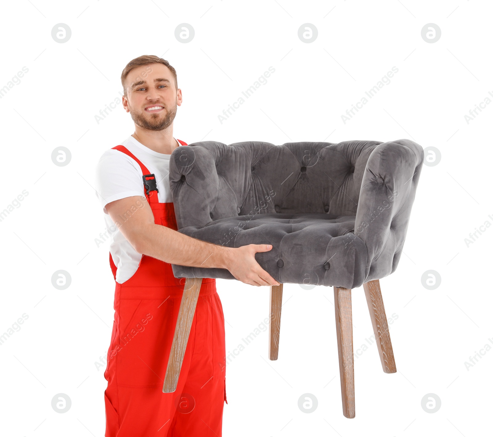 Photo of Young worker carrying armchair isolated on white. Moving service