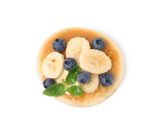 Delicious pancake with banana slices, blueberries and mint isolated on white, top view