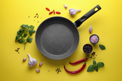 Flat lay composition with frying pan and fresh products on yellow background