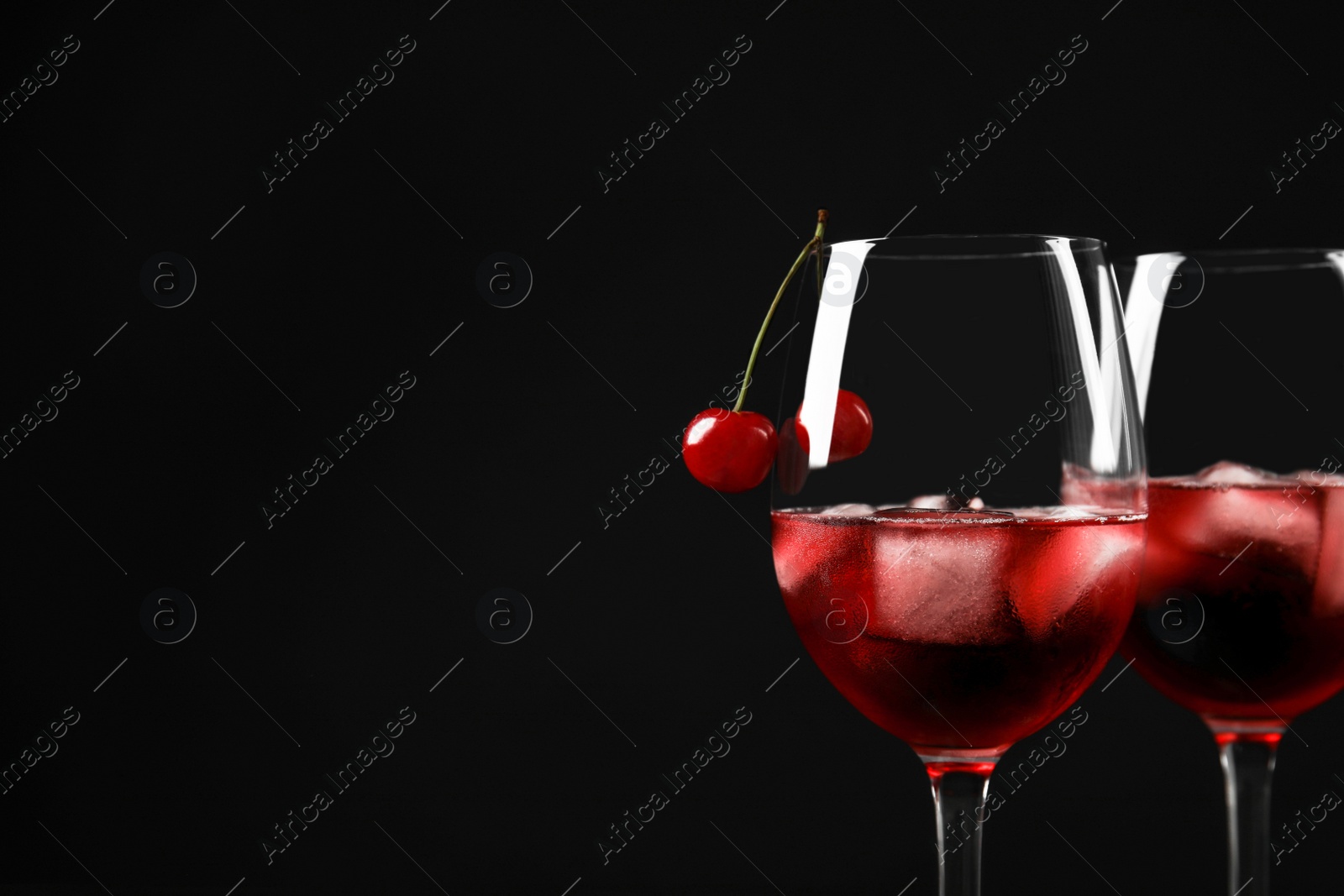 Photo of Delicious cherry wine with ripe juicy berries on black background. Space for text