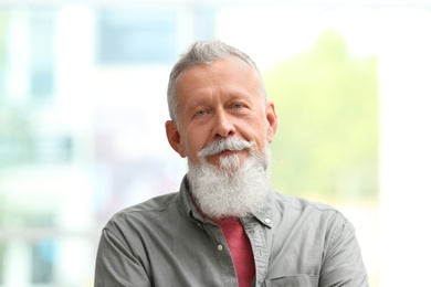 Portrait of handsome mature man against blurred background