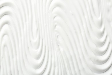 Photo of Texture of face care cream as background, top view