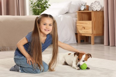 Photo of Cute girl playing with her dog in bedroom at home. Adorable pet