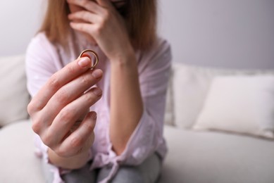 Photo of Woman with wedding ring indoors, space for text. Divorce concept