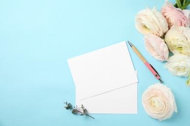 Flat lay composition with spring ranunculus flowers and cards on color background. Space for text