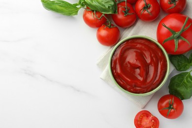 Bowl of tasty ketchup, tomatoes and basil on white marble table, flat lay. Space for text