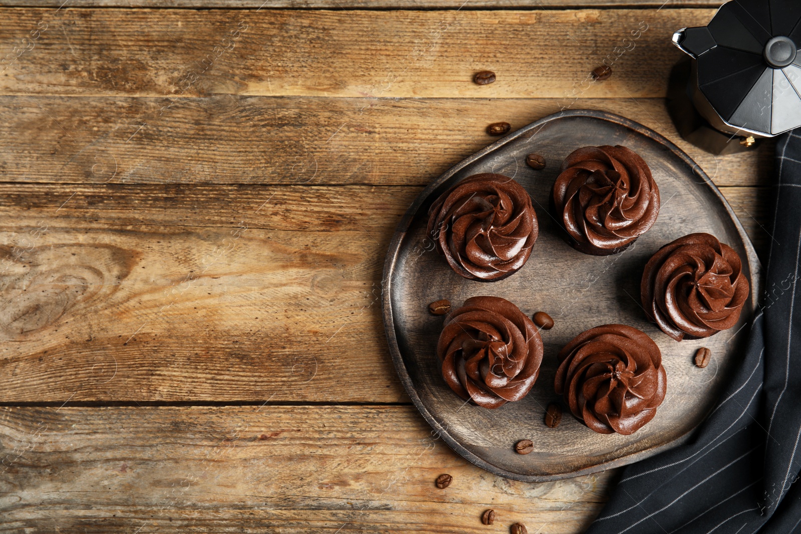 Photo of Flat lay composition with delicious chocolate cupcakes on wooden table. Space for text