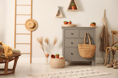 Grey chest of drawers in stylish room interior