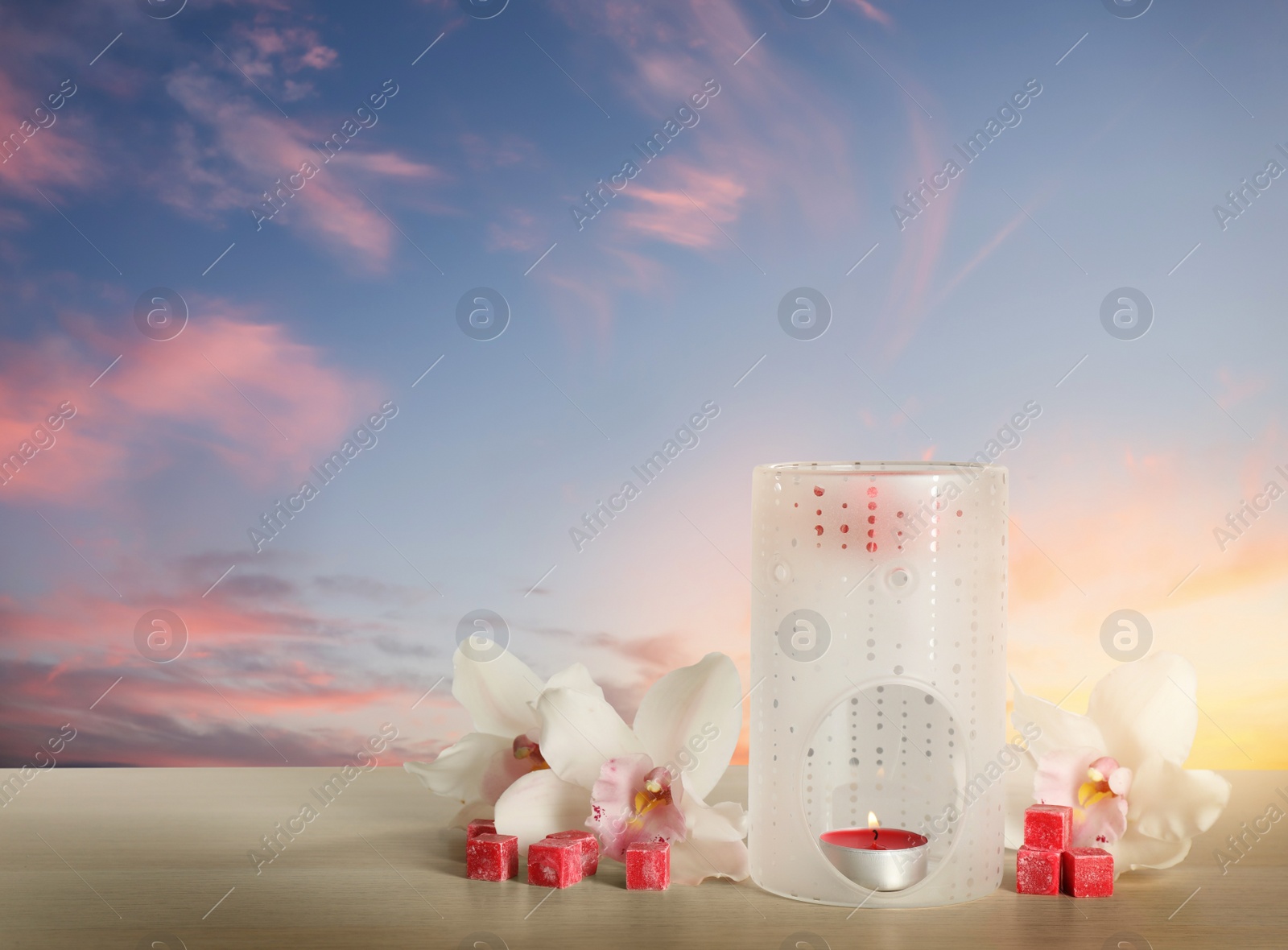 Image of Composition with aroma lamp on wooden table outdoors at sunset, space for text