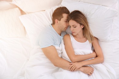 Image of Young couple sleeping on soft pillows in bed at home, top view