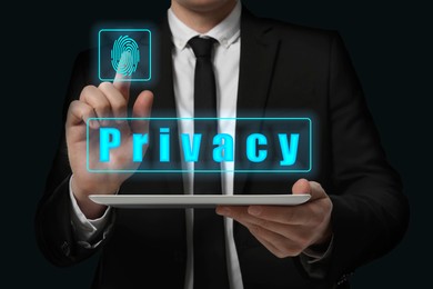 Image of Privacy policy. Businessman activating privacy feature on virtual screen while holding tablet against black background, closeup