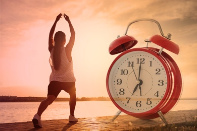 Image of Workout time. Double exposure of woman doing exercise on sunny morning outdoors and alarm clock, color toned