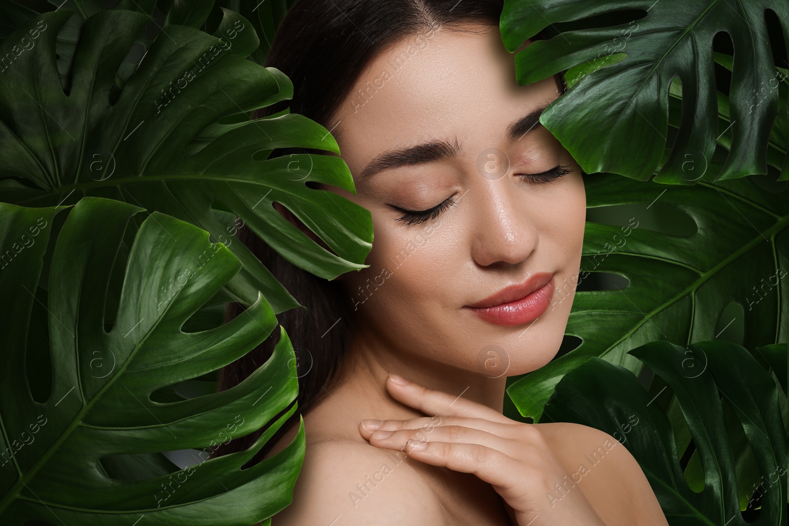 Image of Beautiful young woman feeling harmony while enjoying nature. Girl surrounded by green leaves