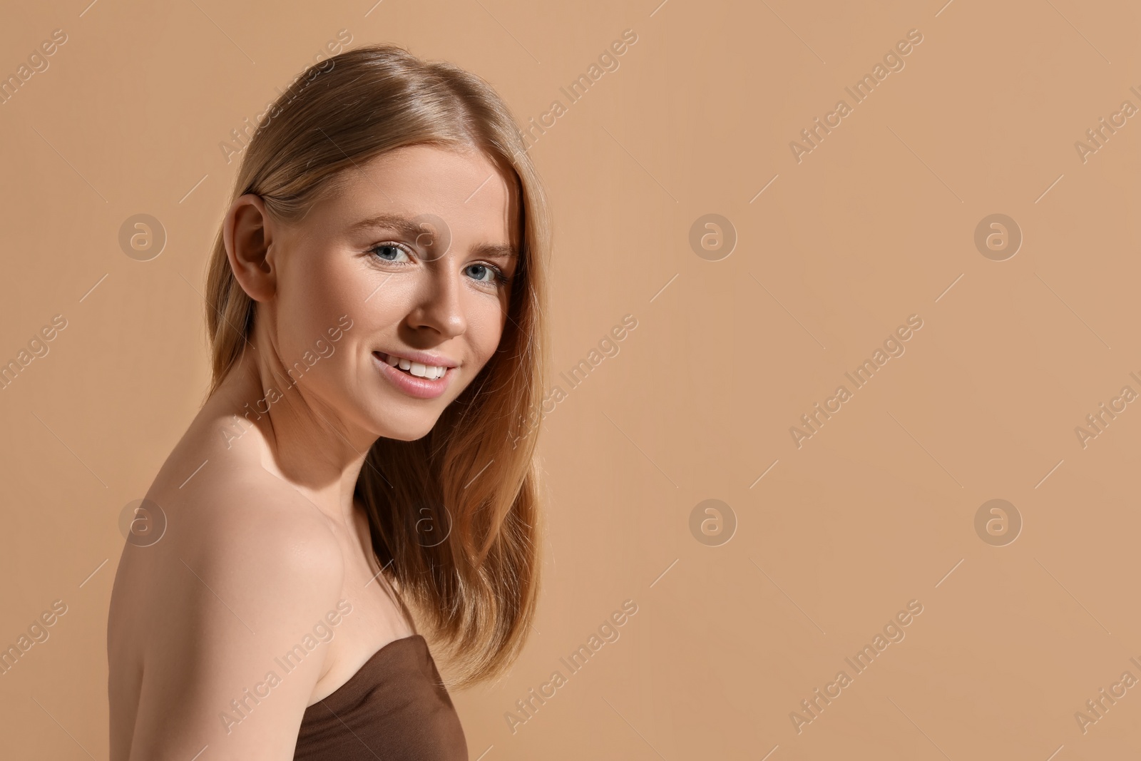 Photo of Beautiful young woman posing on beige background, space for text