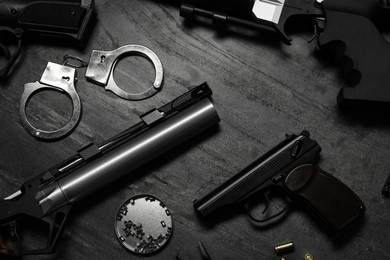 Photo of Flat lay composition with different guns on dark table