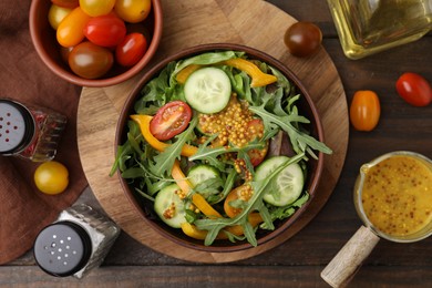 Salad with tasty vinegar based sauce (Vinaigrette) in bowl and spices on wooden table, flat lay